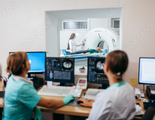 Nurse preparing patient for CT scan test in lab