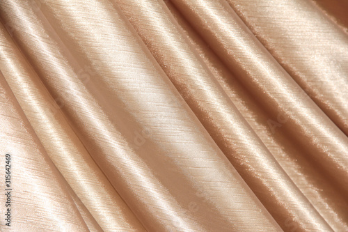 Beige background of curtains draped with waves