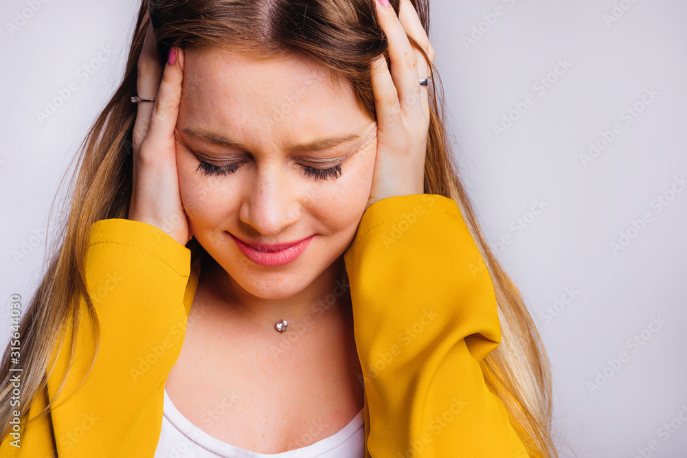 Naklejka premium girl with a beautiful make-up in a yellow jacket closed her ears