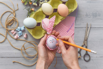 woman makes cute decorative eggs for easter holiday. do-it-yourself easter gifts concept. cute pastel colored eggs