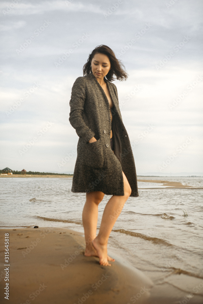 Woman portrait in coat on sea beach Woman portrait in coat on sea beach