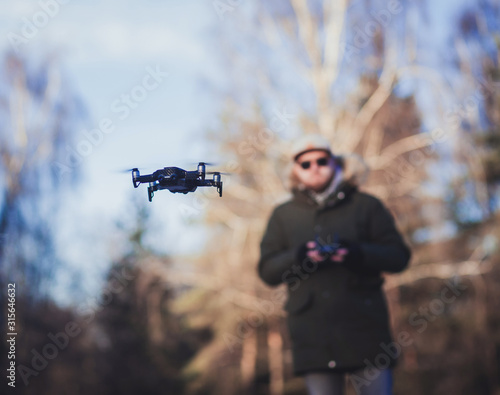 flying black drone on the background of a man. focus on the drone