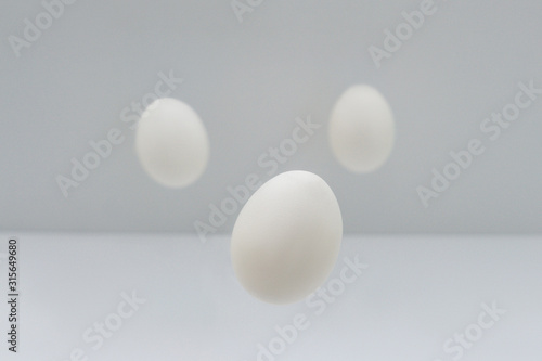 Flying easter white eggs on white background.