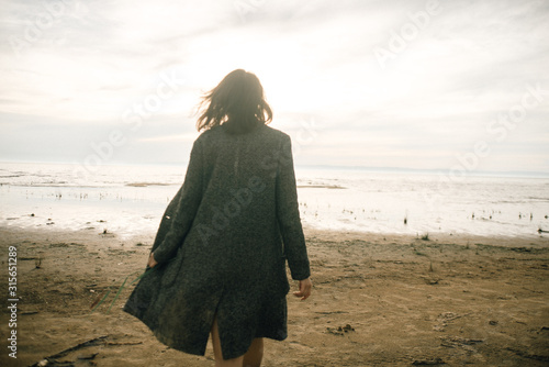Woman portrait in coat on sea beach 