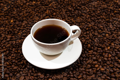 White coffee mug on the coffee beans background