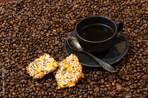 White coffee mug and cookies on the coffee beans background
