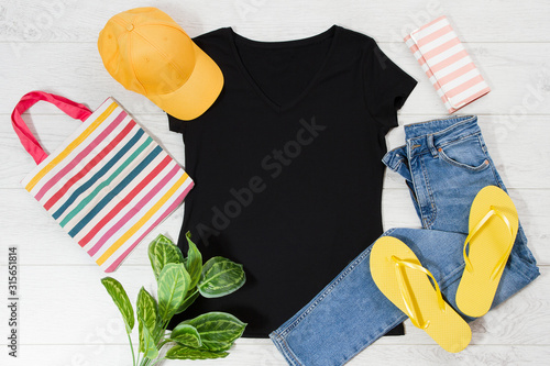 T shirt black and slippers. T-shirt Mockup flat lay with summer accessories. Hat, bag, yellow flip flops on wooden floor background. Copy space. Template blank canvas. Front top view. photo