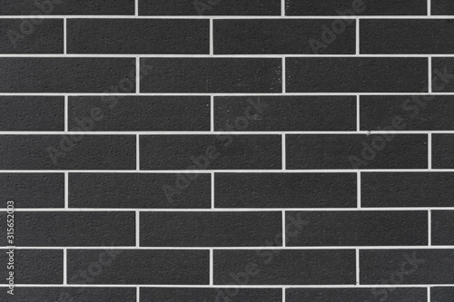 brick wall with black bricks and white filling at square format as background and texture
