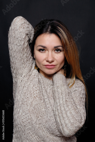 Portrait of beautiful red haired female in grey melange sweater with hair