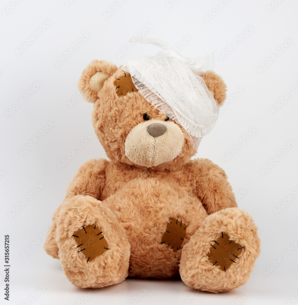 big teddy bear with a bandaged head in a white medical bandage on a white background big teddy bear with a bandaged head in a white medical bandage on a white background