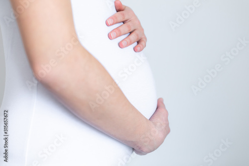 young pregnant woman caressing her tummy