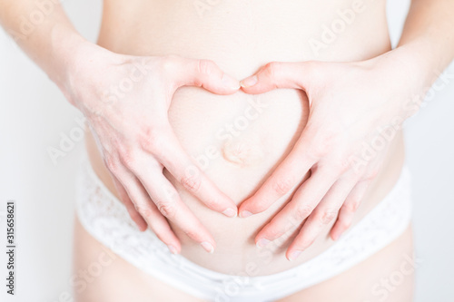 Wallpaper Mural hands in the shape of a heart on a belly of a young pregnant woman Torontodigital.ca