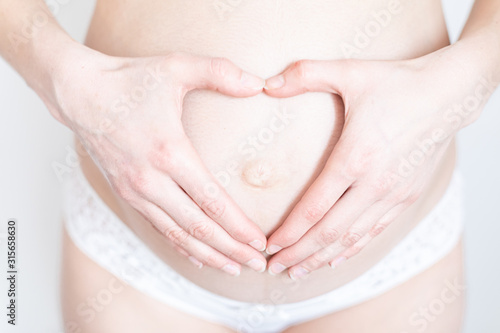 Wallpaper Mural hands in the shape of a heart on a belly of a young pregnant woman Torontodigital.ca