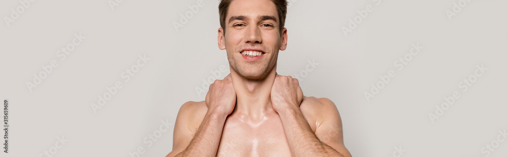 Obraz premium smiling sexy man with muscular torso posing isolated on grey, panoramic shot