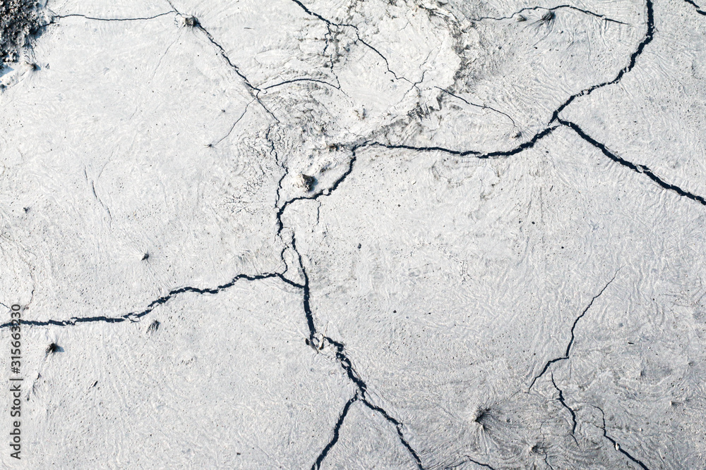 Obraz premium The structure of the earth's surface cracks, soil on a white background, desert cracks, arid surfaces in the dry ground, with many fissures and scratches