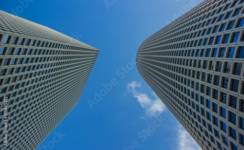 skyscraper construction buildings modern city center towers gray wall exterior architecture object foreshortening from below on blue sky background