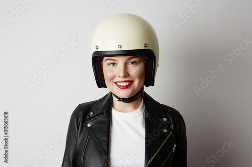 Young biker woman posing o the white background. Isolated. © face_reader_img