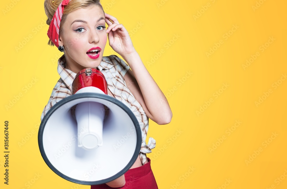 Fototapeta premium Portrait of woman holding megaphone, dressed in pin-up style