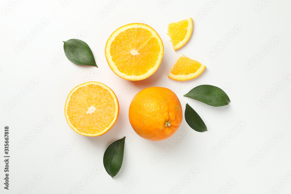 Oranges and leaves on white background, top view Oranges and leaves on white background, top view