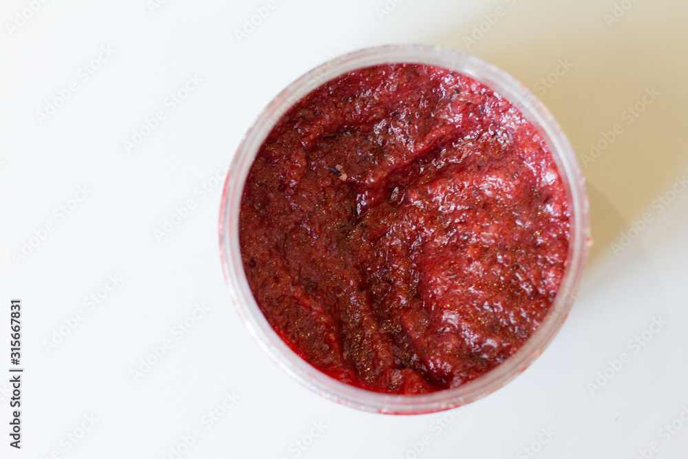 red body scrub made from natural salt. a jar of cosmetics on a white background. body care. SPA at home and in the beauty salon. The concept of female beauty and body care. against cellulite. red body scrub made from natural salt. a jar of cosmetics on a white background. body care. SPA at home and in the beauty salon. The concept of female beauty and body care. against cellulite.