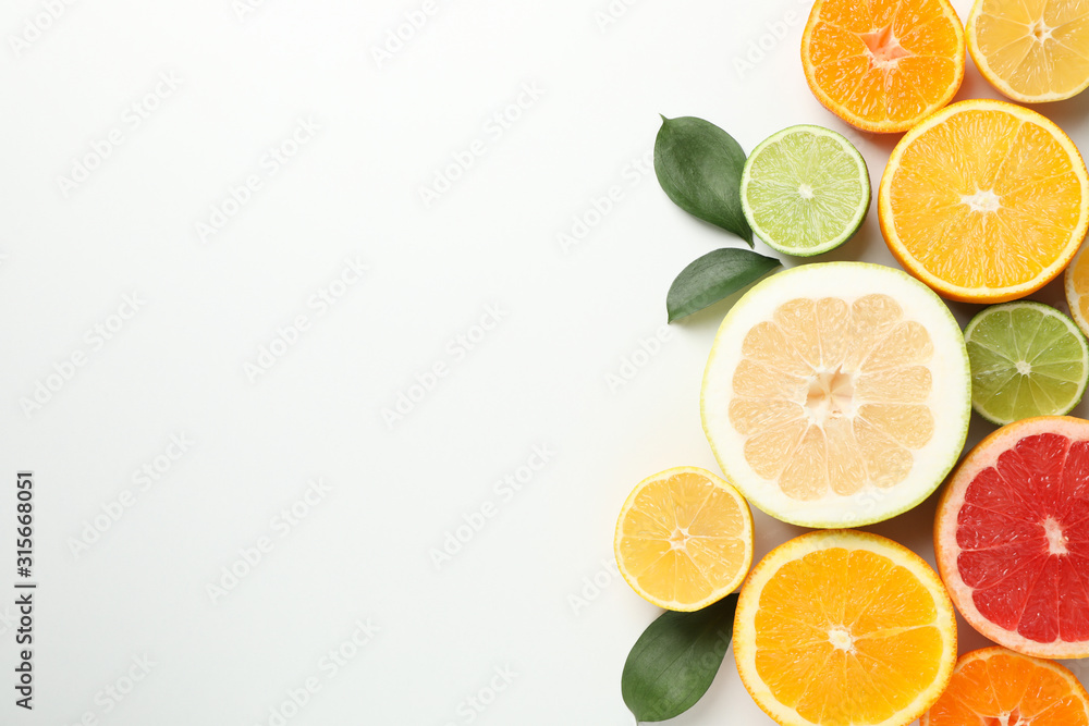 Citrus fruits and leaves on white background, space for text Citrus fruits and leaves on white background, space for text