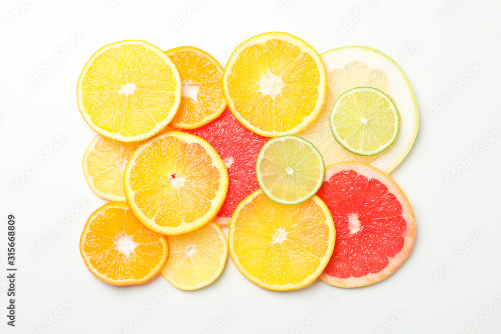 Citrus fruits slices on white background, top view