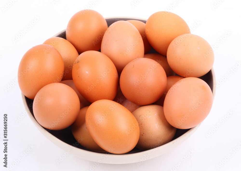 brown eggs in black bowl on white background brown eggs in black bowl on white background
