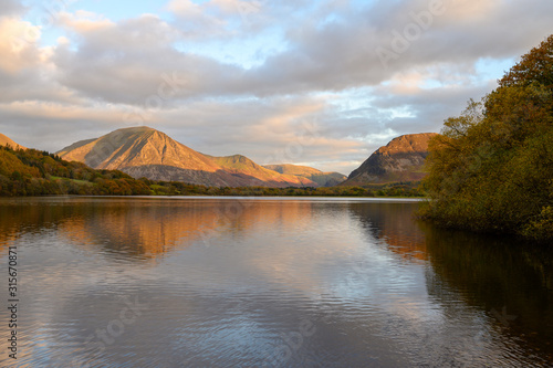 Sunset reaches the top of Grasmoor Fell looking across Loweswater in The Lake District,Cumbria,UK.