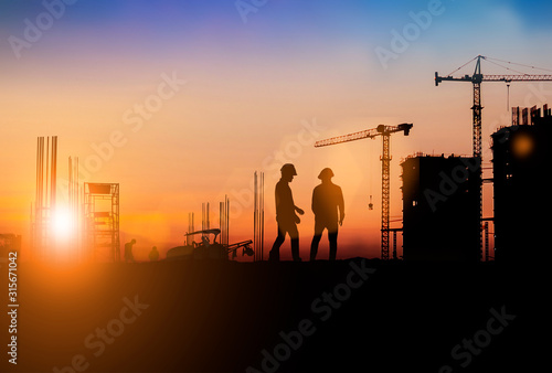 Silhouette of Survey Engineer and construction team working at site over blurred industry background with Light fair Film Grain effect.Create from multiple reference images together