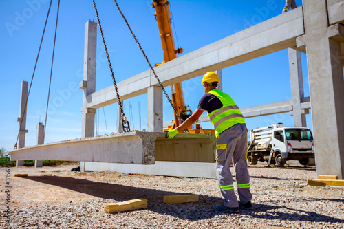 Workers are helping crane from the ground, keep balance and direction