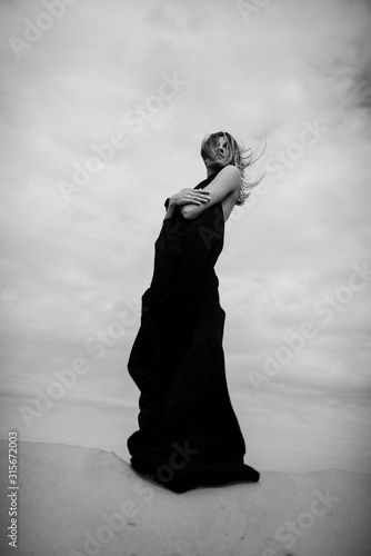 Woman in black dress portrait in desert 