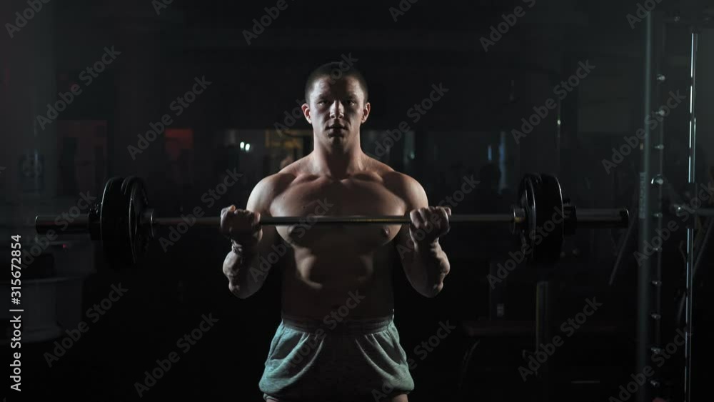 andsome Muscular Man Does Deadlift and Curls with a Heavy Barbell. Athletic Shirtless Man Training, Doing Power, Strength and Endurance Exercises with Barbell. Workout in the Hardcore Gym andsome Muscular Man Does Deadlift and Curls with a Heavy Barbell. Athletic Shirtless Man Training, Doing Power, Strength and Endurance Exercises with Barbell. Workout in the Hardcore Gym
