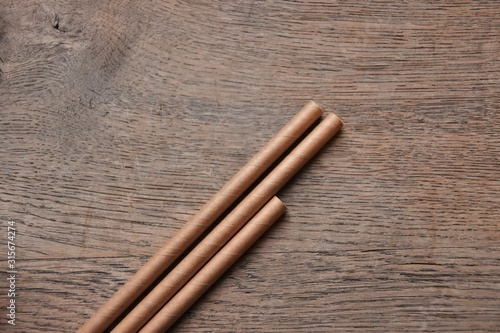 Eco friendly Reusable Straws in the cardboard cup with selective focus and blurred background. Paper cocktail tubes. Kraft paper straw for drinking coffee or tea. Disposable cocktail tube. 
