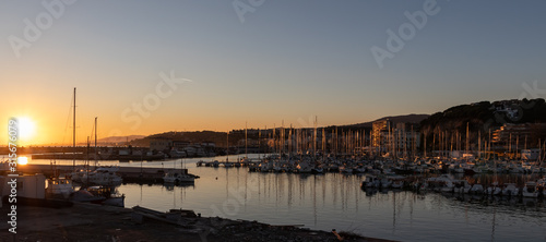 Photography Beautiful sunset panoramic view of a port at sunset with multiple sailboats