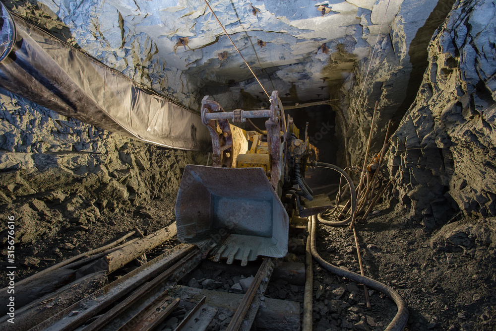Fototapeta premium Underground gold mine shaft tunnel drift with loading machine eimco