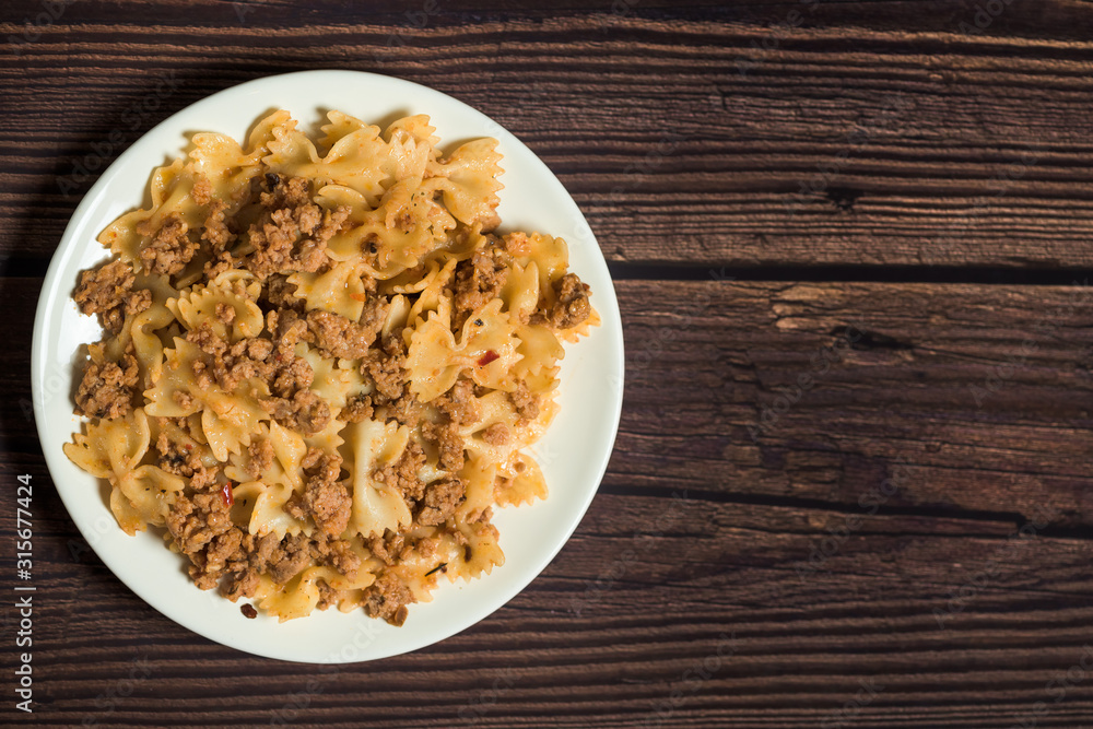 fresh delicious nutritious pasta with pork meat on a wooden background . the view from the top. photo for banner, place for text fresh delicious nutritious pasta with pork meat on a wooden background . the view from the top. photo for banner, place for text