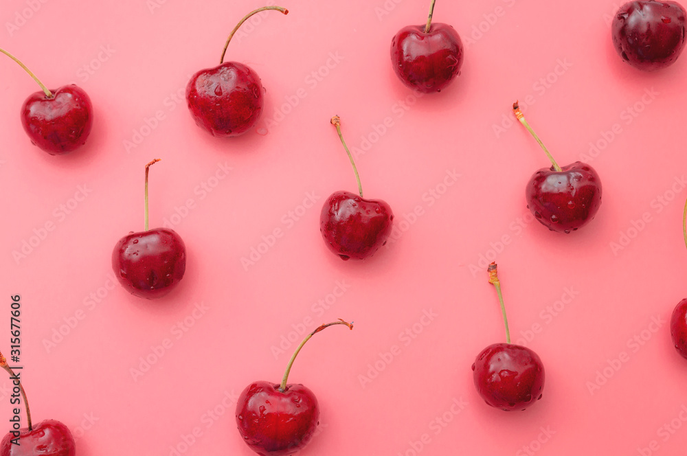 Summer vitality, tasty natural lush fruit and beautiful summer pattern concept theme with group of wet red cherries with water drops filling the frame isolated on pink background Summer vitality, tasty natural lush fruit and beautiful summer pattern concept theme with group of wet red cherries with water drops filling the frame isolated on pink background