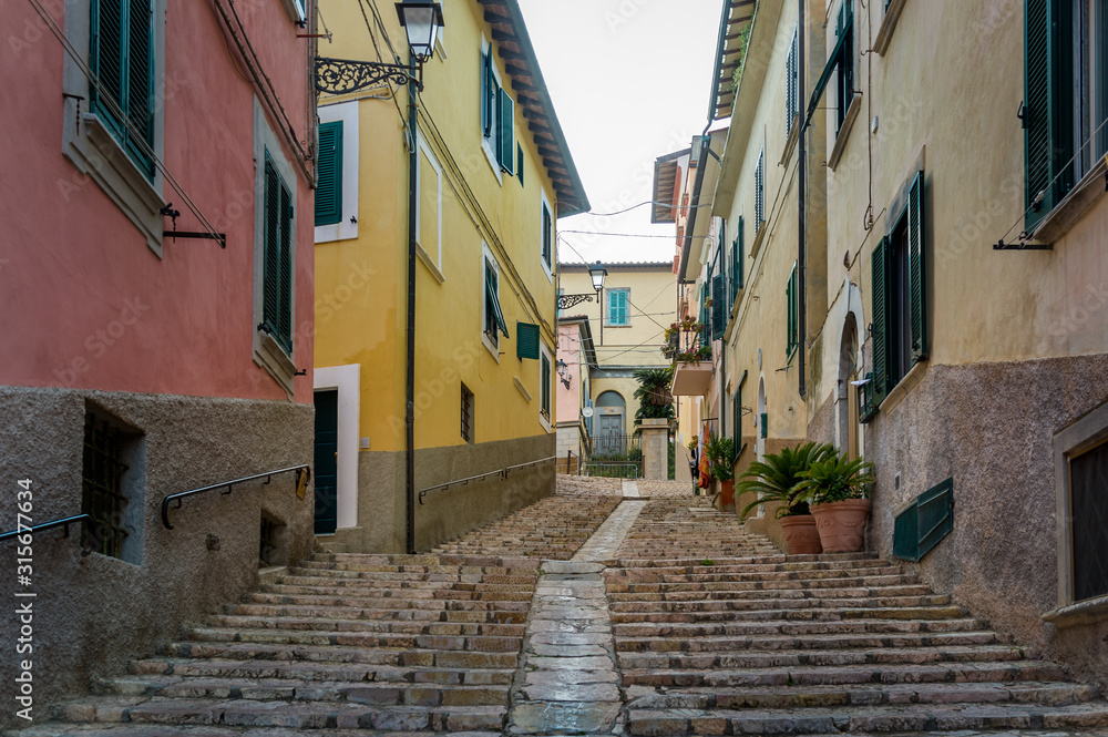 Uphill walking street of Portoferraio with traditional colorful houses, Elba island, Italy