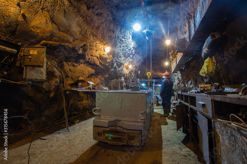 Underground gold mine miners repairs the locomotive