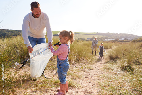 Foto Multi-Generation Family Collecting Litter On Winter Beach Clean Up