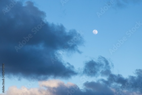 Day moon among clouds