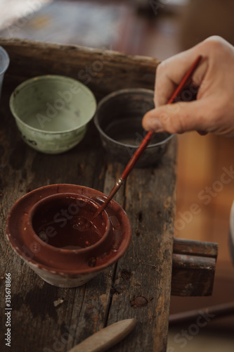 Craftsman decorates handmade terracotta