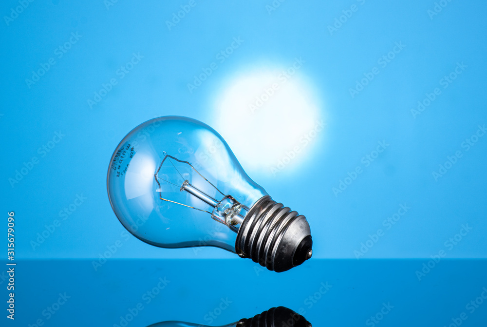 falling round incandescent lamp on a blue background falling round incandescent lamp on a blue background
