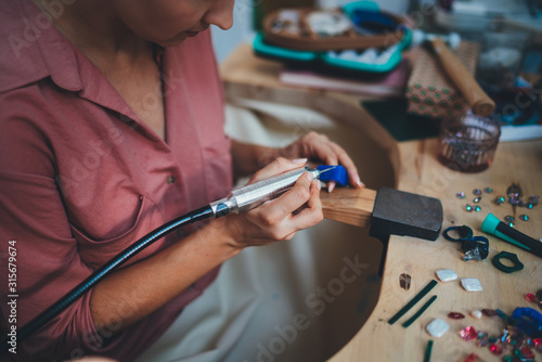 Cropped Image of Unrecognizable Young Woman sitting in Jewelry Workshop Using Jewelry Tools Upright Drill, Woman Making Ring at her Studio, Handmade Creativity People Goldsmith