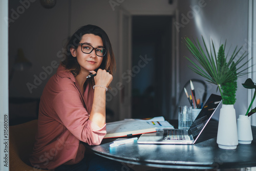 Pretty young woman an advertising copywriter in eyeglasses working at home using laptop, female graphic designer working in modern studio, Networking Freelancer Businesswoman Designer Entrepreneur
