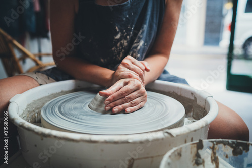 Closeup Frontal Shot of Professional Female Ceramic Artist Makes Masterclasses on Pottery Wheel in Cozy Studio Sharing Skills, Artisan Handcrafted Creative People Workshop photo