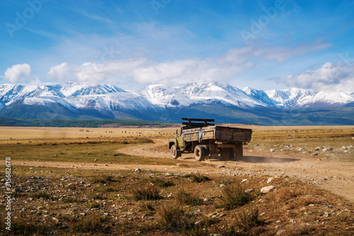Altai Republic, Russia - September, 15, 2019: ZiL-130 truck driving along a field road, the North Chuy Range on the horizon