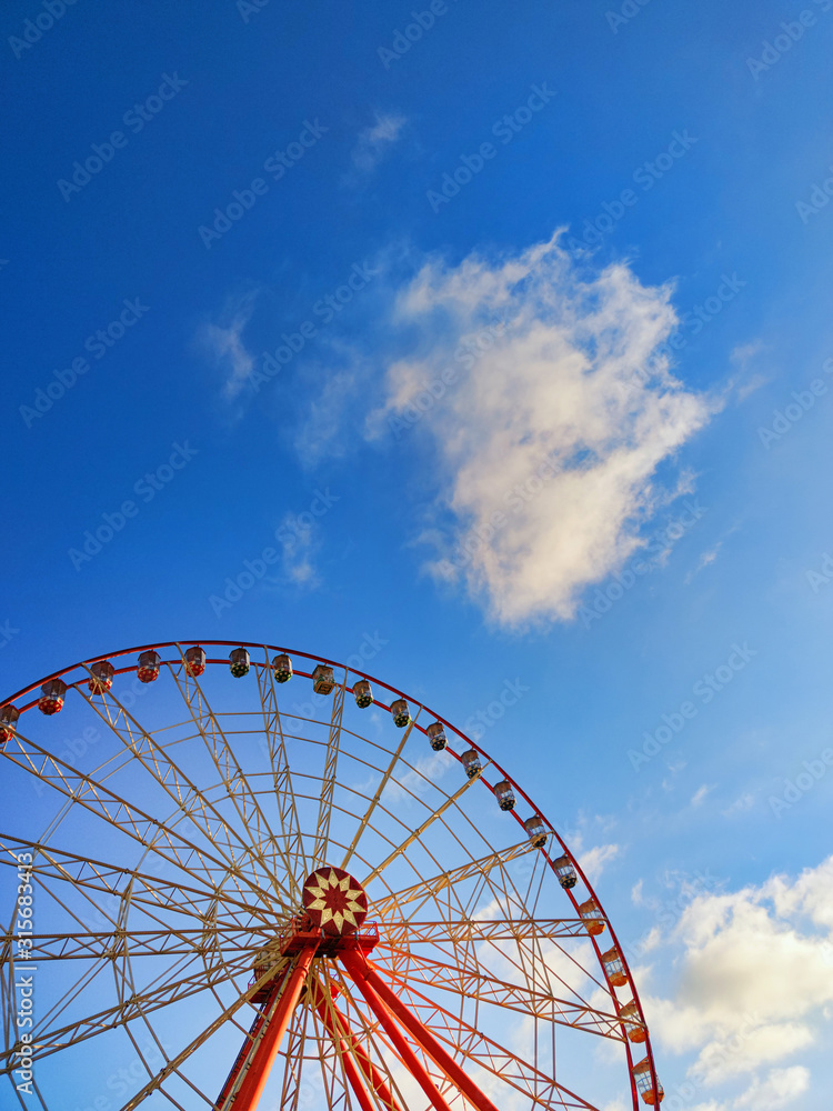 Part of ferris wheel with  soft clouds at sunset