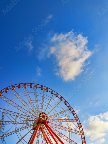 Part of ferris wheel with soft clouds at sunset