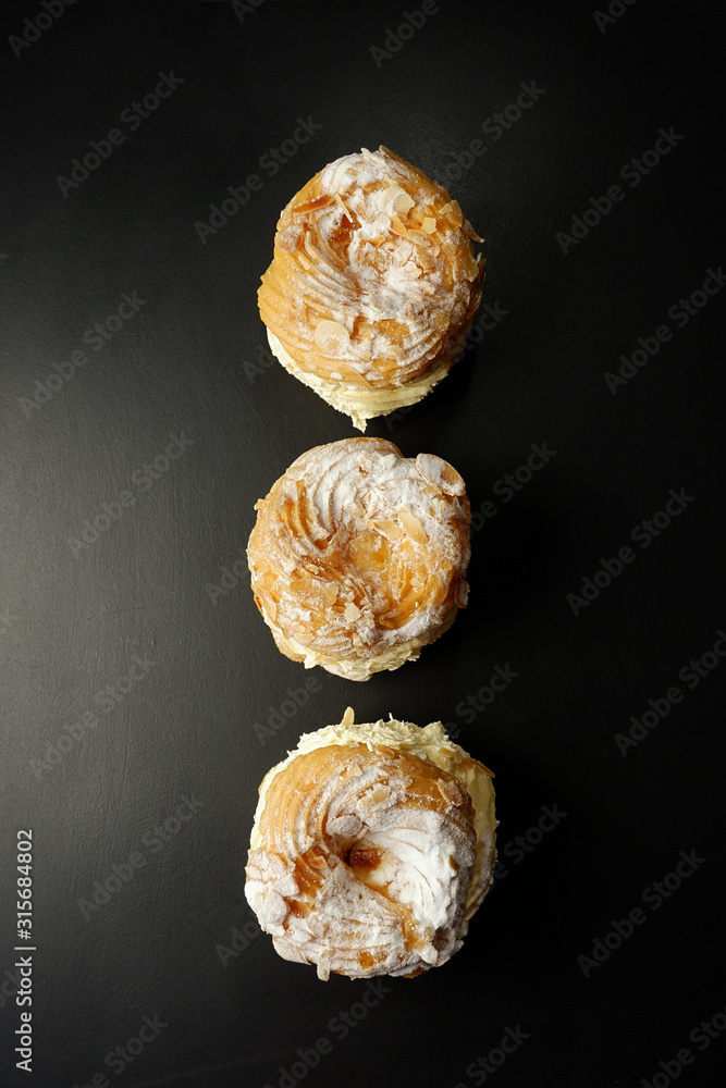 Profiteroles cake on a black background, empty space for text Profiteroles cake on a black background, empty space for text